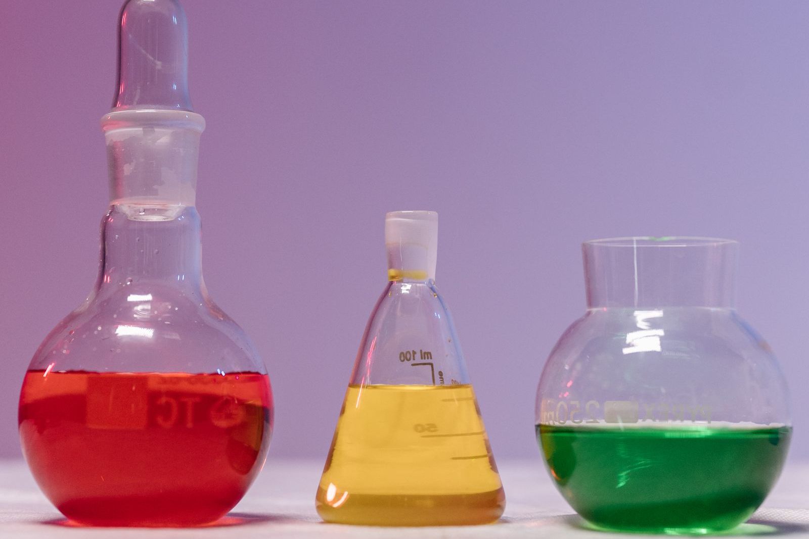 Tres matraces de vidrio con líquidos de colores en un laboratorio